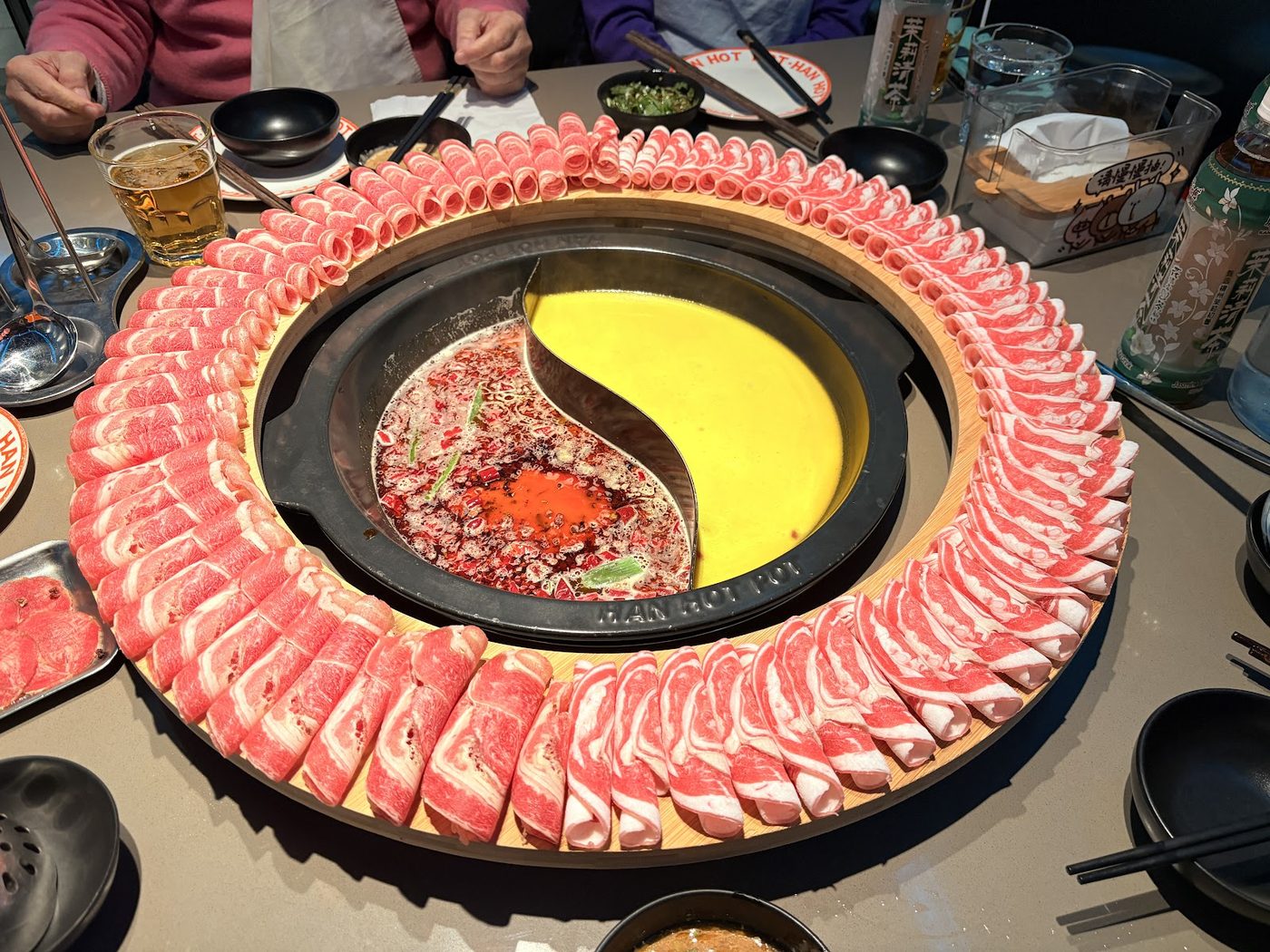 Sliced meat arranged around a hot pot